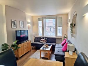 London City Apartments في لندن: غرفة معيشة مع أريكة وتلفزيون