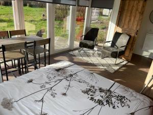 a bedroom with a bed and a table and chairs at Containerwoning op schitterende locatie in Milsbeek