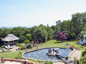 a large swimming pool with a gazebo in a park at The Cottage in Fairlight