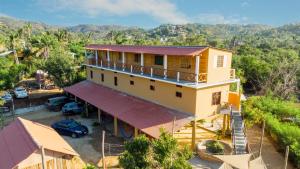 ein gelbes Haus mit einem Balkon auf dem Dach in der Unterkunft Hotel La Playa in Mazunte
