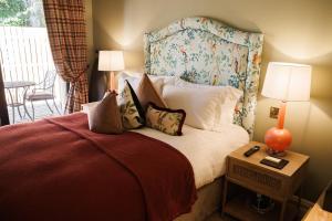 a bedroom with a bed with a floral headboard and pillows at Tankardstown House in Slane