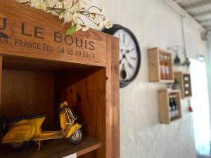 un scooter amarillo de juguete sentado dentro de un estante de madera en Château le Bouïs, en Gruissan