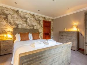 a bedroom with a large bed with two night stands at The Old Boathouse in Cromdale