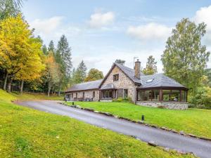 a stone house on a hill with a road at The Old Boathouse in Cromdale