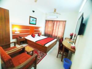 a bedroom with a bed and a table and a desk at Hotel Supreme in Sylhet