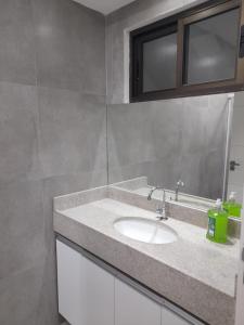 La salle de bains est pourvue d'un lavabo et d'un miroir. dans l'établissement FLATS MANOEL TAVARES, à Garanhuns