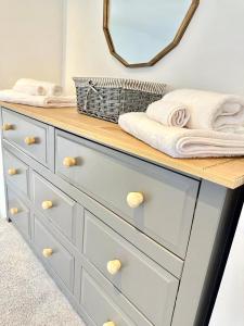 a dresser with a counter with towels on it at Cosy One Bedroom Apartment in Trowbridge