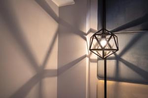 a light fixture on a wall with shadows on the wall at Best Western Plus Sabaudia Hotel in Sabaudia