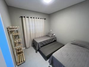 1 dormitorio pequeño con 2 camas y estante en Duplex Byron Beach Residence, en Bombinhas