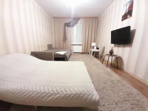 ヴィーシュホロドにあるUpTown-Квартираのベッド1台、薄型テレビが備わるホテルルームです。