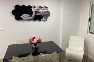 Moderno apartamento en Elche في إلتشي: طاولة غرفة طعام مع صورة لامرأة