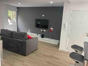 a living room with a couch and a flat screen tv at Moderno apartamento en Elche in Elche