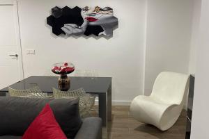 a living room with a table and a chair at Moderno apartamento en Elche in Elche