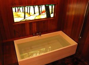 a bath tub in a room with a window at Tsukihitei in Nara