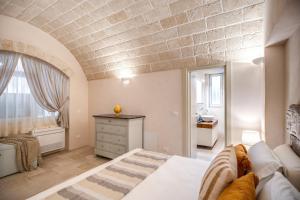 a bedroom with a large bed and a bathroom at Trullo Rosa del Sud-Benessere SPA in Ceglie Messapica