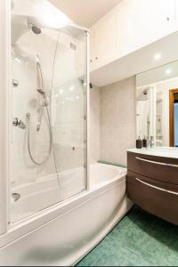 een badkamer met een bad, een douche en een wastafel bij Forum Assago appartamento in Assago