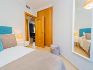 een slaapkamer met een bed en een spiegel bij Cubo's Liberty Apartment in Alhaurín el Grande