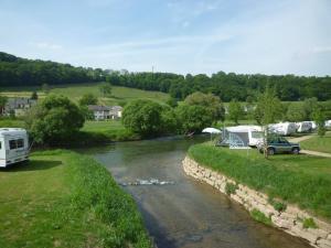 a river with vehicles parked next to a campsite at Leaf camping Reisdorf in Reisdorf