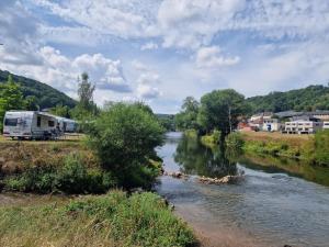 uma caravana estacionada ao lado de um rio em Leaf camping Reisdorf em Reisdorf