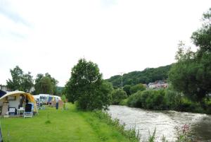 a river with a group of tents next to a river at Leaf camping Reisdorf in Reisdorf