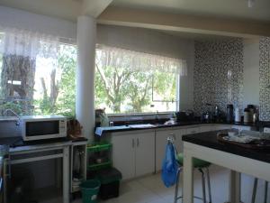 a kitchen with a sink and a microwave on a counter at ROSA CORTIANA Escalera in São Gabriel