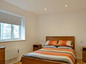 Schlafzimmer mit einem Bett und einem Fenster in der Unterkunft Tawny Owls in Godstone