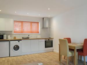 a kitchen with a table and a dining room at Tawny Owls in Godstone