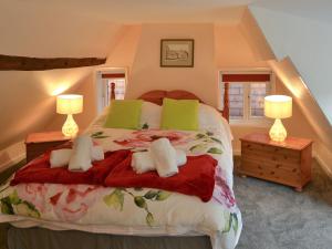 a bedroom with a large bed with two lamps at The Brambles in Horning