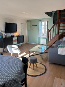 uma sala de estar com um sofá e uma mesa em Charmant appartement 4 pers au centre des remparts em Guérande
