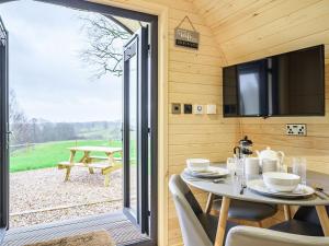 una mesa de comedor en una casa pequeña con una puerta corredera de cristal en Coton - Ukc5324, en East Haddon