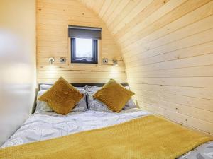 uma cama num quarto com uma parede de madeira em Coton - Ukc5324 em East Haddon