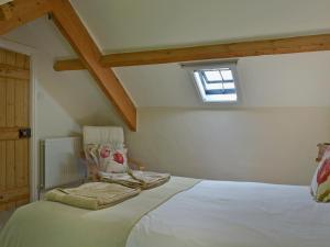 a bedroom with a large white bed with a window at Load Pot in Watermillock