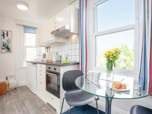 eine Küche mit einem Glastisch und einem Fenster in der Unterkunft Apartment Ten - Uk39862 in Paignton