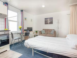 ein Schlafzimmer mit einem Bett, einem Schreibtisch und einem Sofa in der Unterkunft Apartment Ten - Uk39862 in Paignton