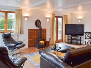 a living room with a couch and a fireplace at Windmill Barn in Herstmonceux