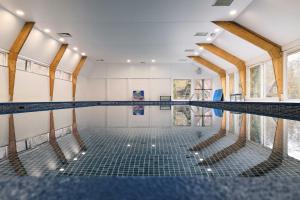 an empty swimming pool with its floors and windows at De Berghut Durbuy - Chalet nr 104 in Durbuy