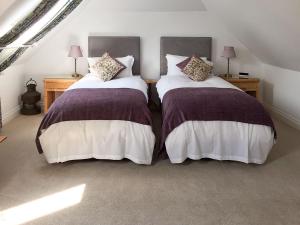 two beds sitting next to each other in a room at Windmill Barn in Herstmonceux
