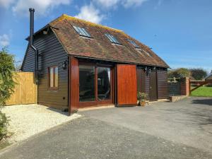 a small house with wooden doors and windows at Windmill Barn in Herstmonceux