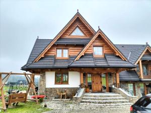 a wooden house with a gambrel roof at Willa u D&J Jarosz in Ząb