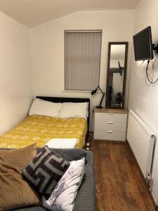 a bedroom with a bed and a couch and a mirror at Haggai COMFORT SUITES in Parkside