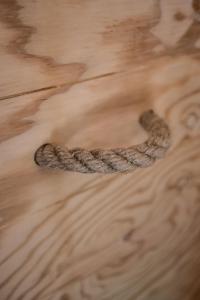 a coiled rope on a wooden table at Luxe woodlodge in een prachtige en bosrijke omgeving in Bornerbroek