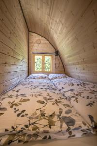 Cama en habitación pequeña con ventana en Luxe woodlodge in een prachtige en bosrijke omgeving, en Bornerbroek