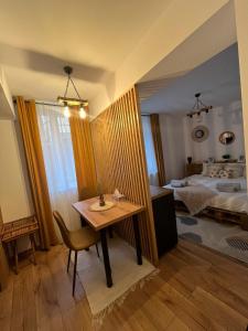 a room with a table and a bed and a bedroom at WOOD Studio Sinaia in Sinaia