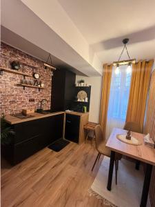 cocina y comedor con mesa y pared de ladrillo en WOOD Studio Sinaia, en Sinaia