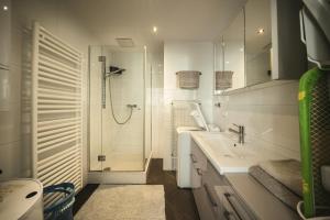 a white bathroom with a shower and a sink at Schlossquadrat Apartement 15 in Vienna
