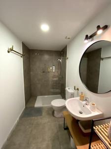 ein Badezimmer mit einem Waschbecken, einem WC und einem Spiegel in der Unterkunft Moderno duplex en la Tacita de Plata in Cádiz