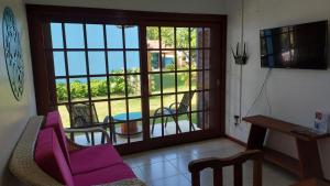 a living room with a balcony with a table and chairs at Condominio Vila Lila in Garopaba