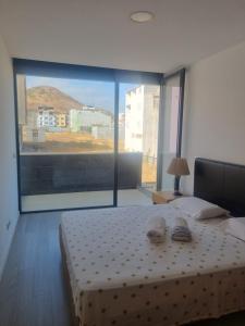 een slaapkamer met een bed en een groot raam bij Kriol Guest House in Praia