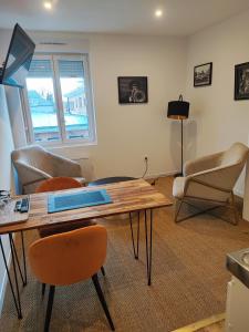 salon ze stołem i krzesłami w obiekcie APPART'HOTEL EDEN w mieście Béthune