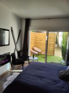a bedroom with a bed and a view of a yard at LoveroomXspa in Bourg-Saint-Christophe
